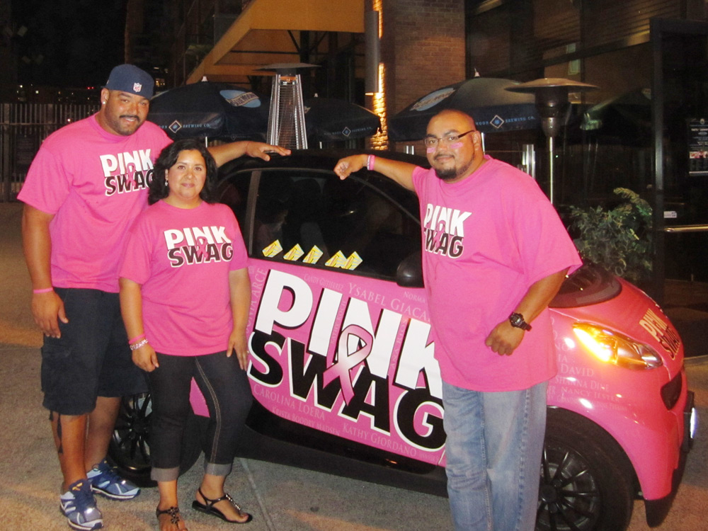Pink Swag supporters beside a branded pink community car