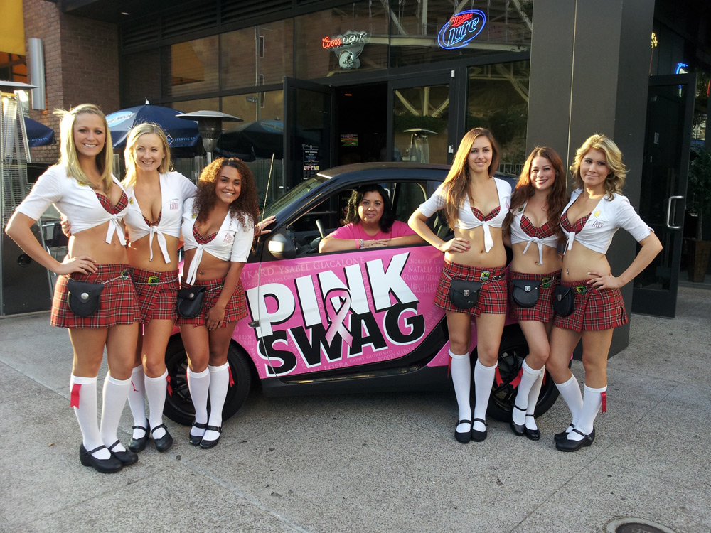 Pink Swag supporters gathered around a bright pink branded car